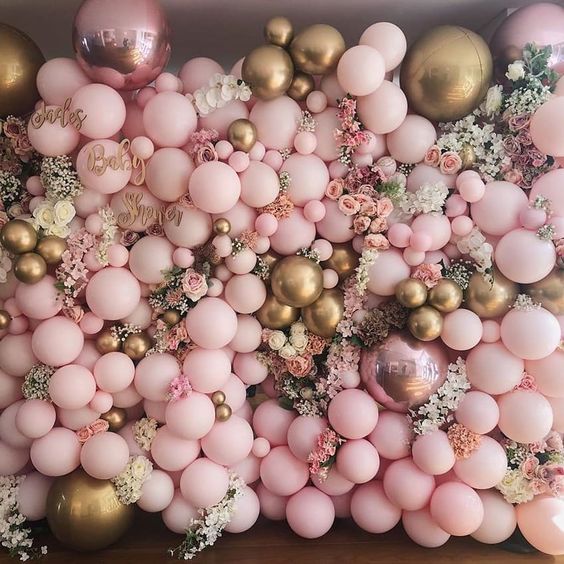 Pink and gold Balloon wall with flowers.