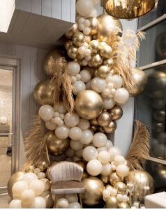 Giant Gold and tan Organic Balloon wall with feather décor.