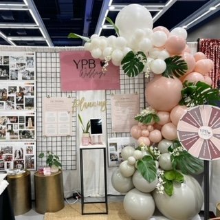 Organic balloon garland with floral arrangements for YPB Seattle wedding show.